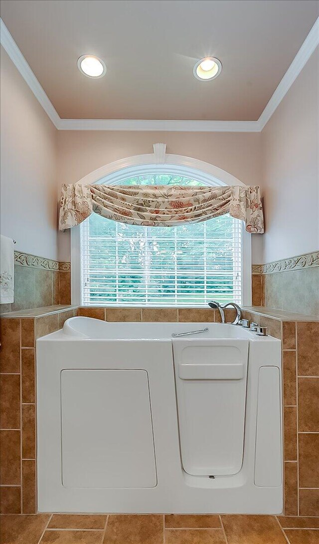 bathroom featuring a tub, ornamental molding, and tile walls