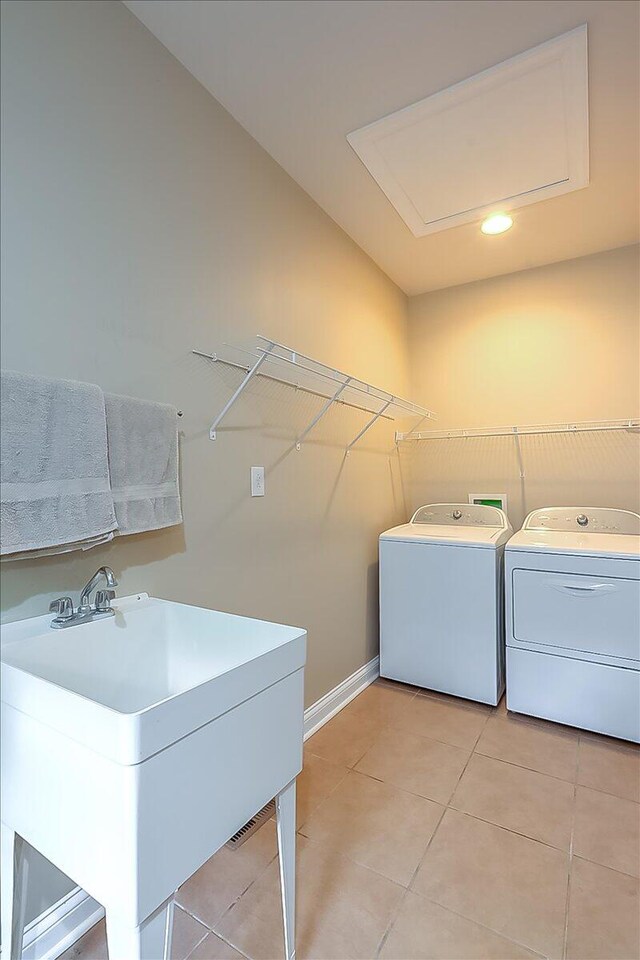 clothes washing area featuring sink, washing machine and clothes dryer, washer hookup, and light tile floors