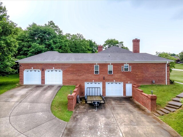 view of front of house with a garage and a front lawn