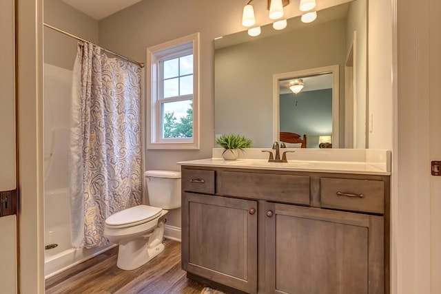 full bath featuring vanity, a shower with curtain, toilet, and wood finished floors