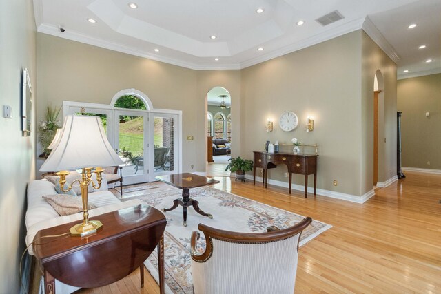 living room featuring ornate columns, ornamental molding, and light hardwood / wood-style floors