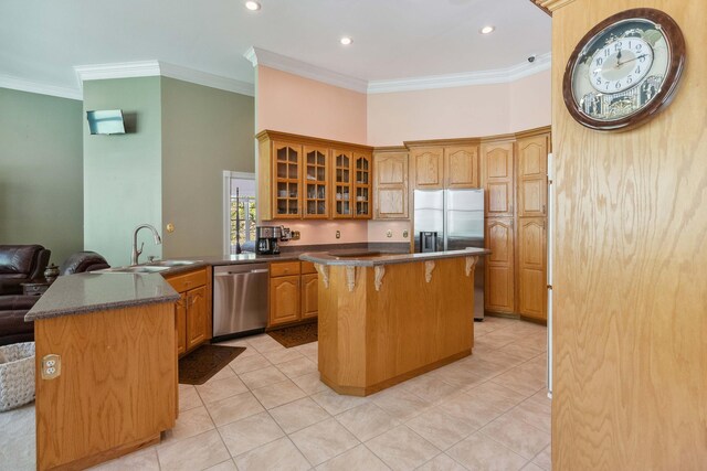 kitchen with ceiling fan, stainless steel appliances, a breakfast bar area, and light tile floors