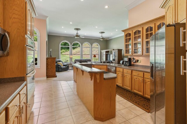 kitchen with light tile flooring, ceiling fan, crown molding, black electric cooktop, and white oven