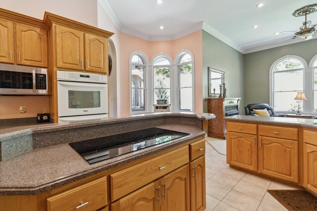 living room featuring ornamental molding, carpet flooring, and ceiling fan