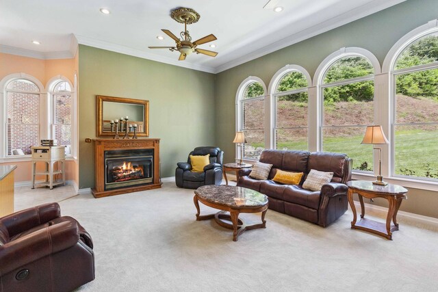 living room with carpet, ornamental molding, and ceiling fan