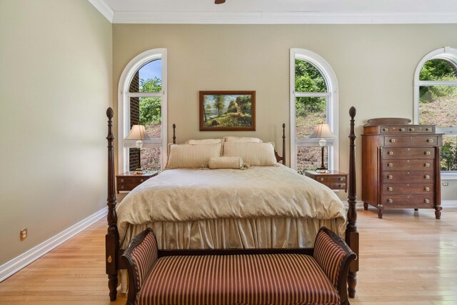 bedroom with ceiling fan, light wood-type flooring, and crown molding