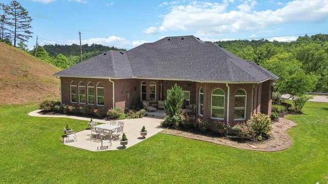 rear view of house with a yard and a patio