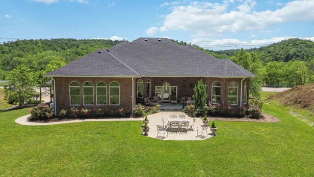 rear view of property featuring a patio and a yard