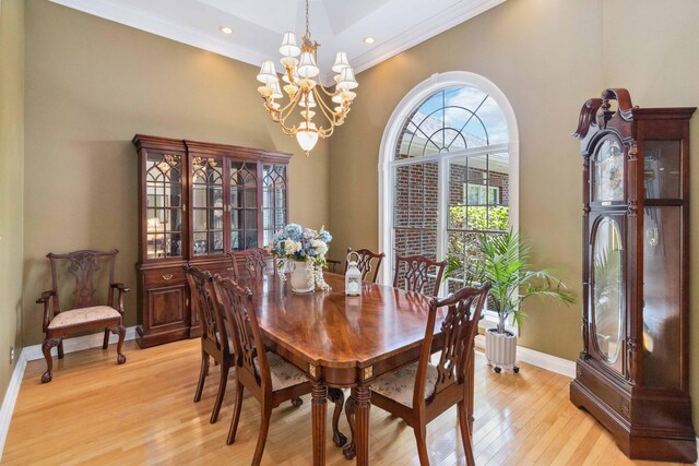 living room with crown molding, ornate columns, a high ceiling, and light hardwood / wood-style flooring