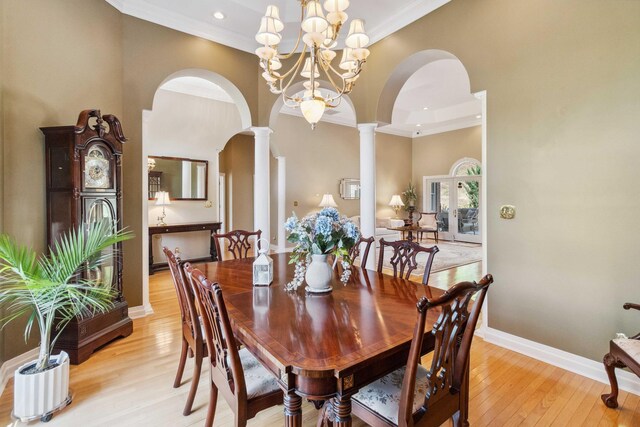 living room with french doors, ornamental molding, light hardwood / wood-style flooring, and a raised ceiling