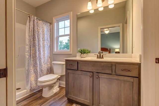 full bathroom featuring toilet, a shower with shower curtain, wood finished floors, and vanity