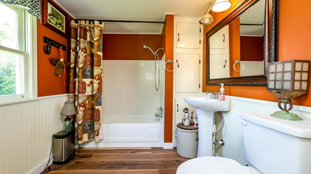 bathroom with shower / tub combo with curtain, hardwood / wood-style floors, and toilet