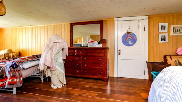 bedroom featuring wooden walls and hardwood / wood-style floors