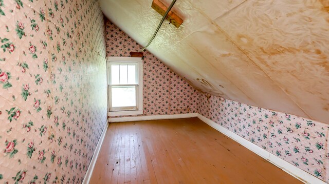 bonus room with lofted ceiling and wood-type flooring