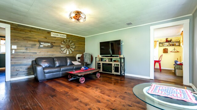 living room with hardwood / wood-style flooring, ornamental molding, and wooden walls