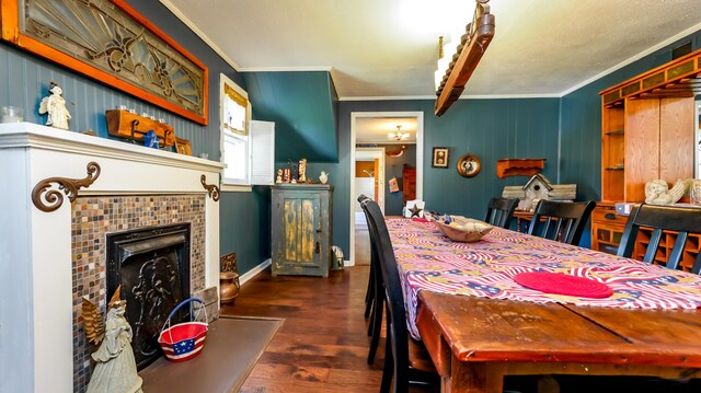 dining room with dark hardwood / wood-style floors, a tile fireplace, and ornamental molding