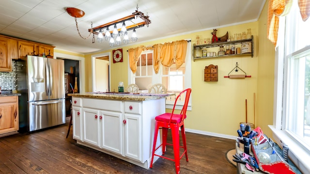 kitchen with stainless steel fridge with ice dispenser, plenty of natural light, dark hardwood / wood-style flooring, and white cabinets