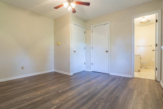 unfurnished bedroom with dark hardwood / wood-style floors, ceiling fan, and ensuite bathroom