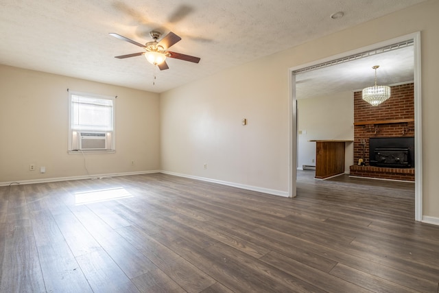 spare room featuring a textured ceiling, ceiling fan, a baseboard radiator, a fireplace, and dark hardwood / wood-style floors