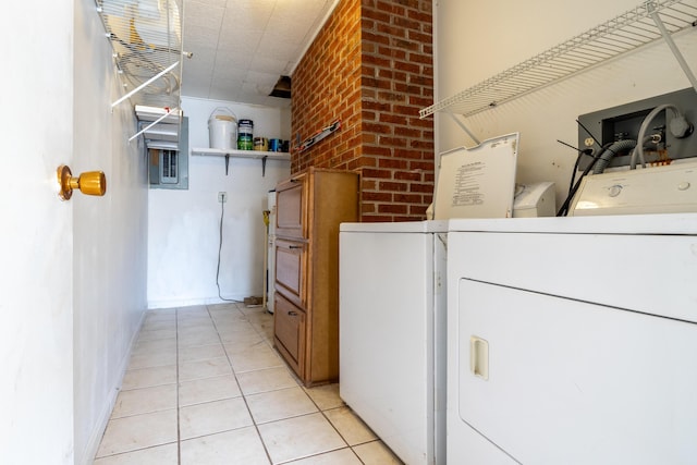 laundry area featuring brick wall, light tile patterned floors, and washing machine and clothes dryer