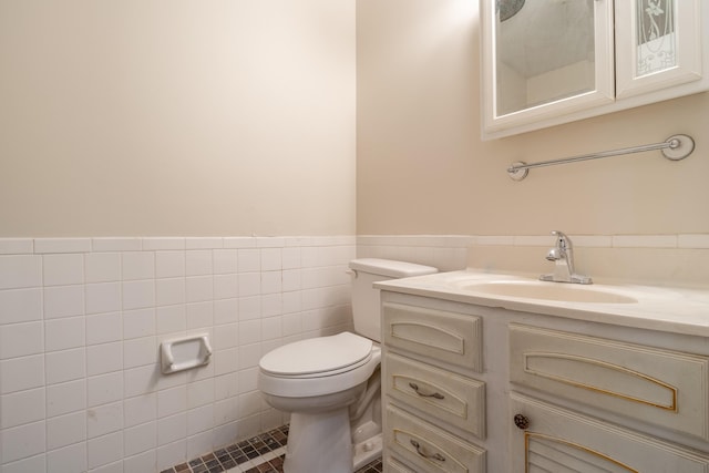 bathroom featuring tile patterned flooring, vanity, tile walls, and toilet