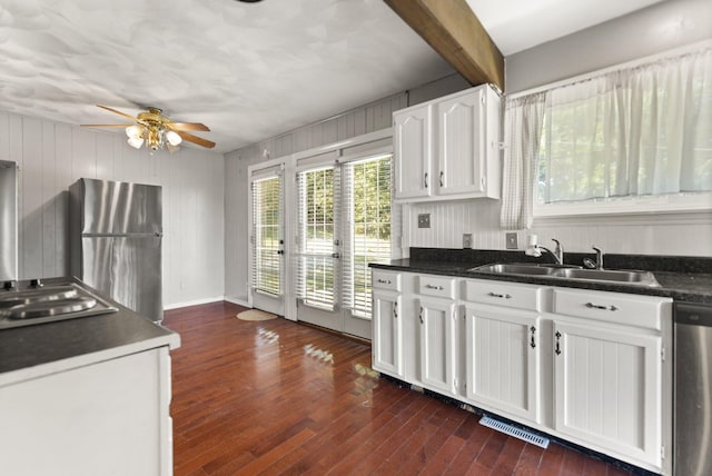 kitchen with appliances with stainless steel finishes, dark wood-type flooring, white cabinets, ceiling fan, and sink