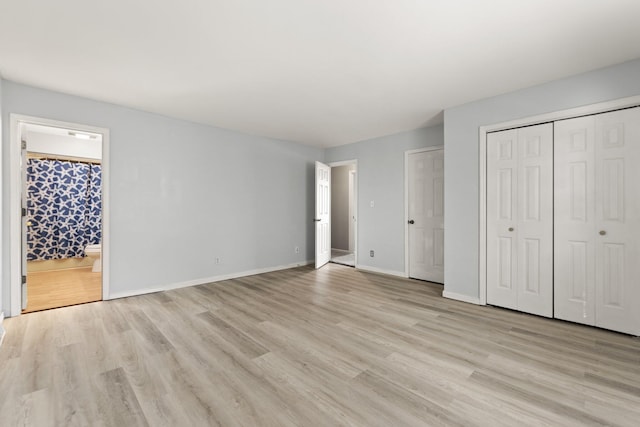 unfurnished bedroom with light hardwood / wood-style floors and ensuite bathroom