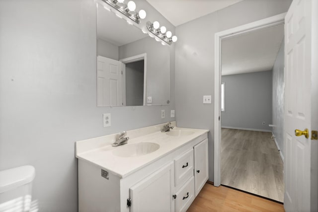 bathroom featuring toilet, vanity, and hardwood / wood-style floors