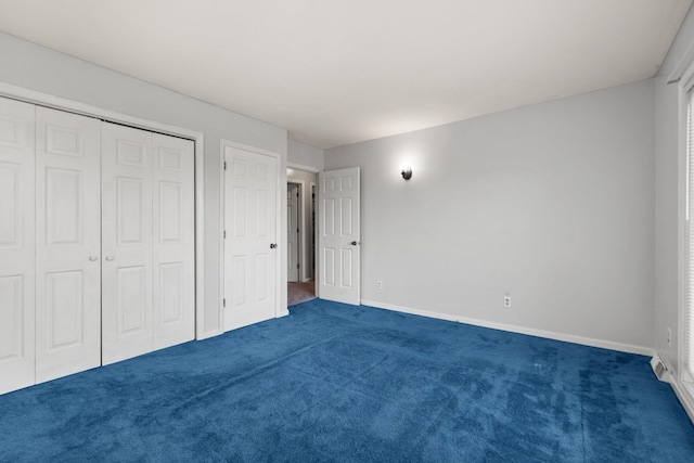 unfurnished bedroom with a closet and dark colored carpet