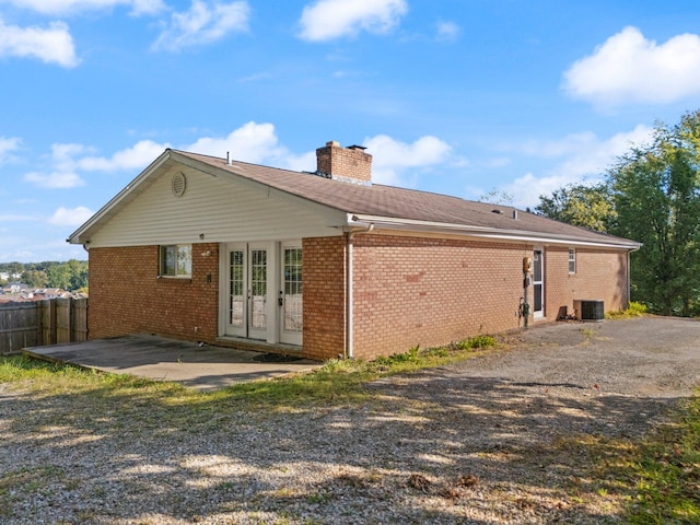 back of house with central air condition unit, french doors, and a patio area