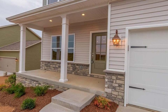 doorway to property featuring a porch and stone siding