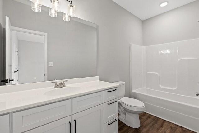 full bathroom with vanity, hardwood / wood-style flooring, toilet, and shower / bathtub combination