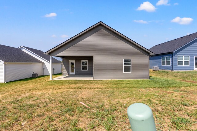 rear view of property featuring a patio, cooling unit, and a yard