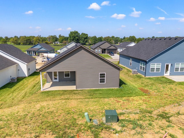 back of property with central air condition unit, a patio, and a lawn