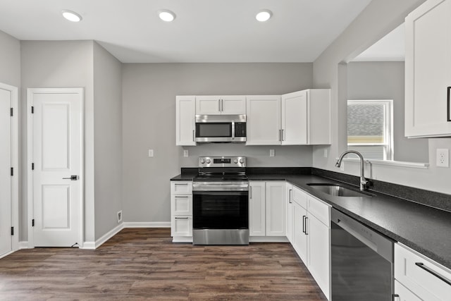 kitchen with sink, white cabinets, stainless steel appliances, and dark hardwood / wood-style floors