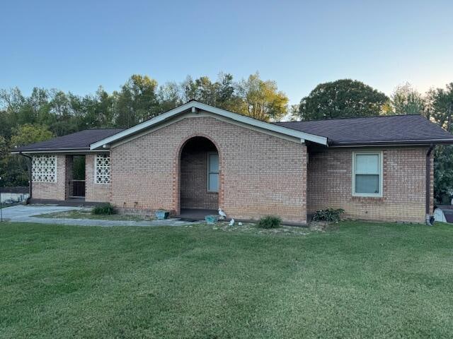 single story home featuring a front lawn