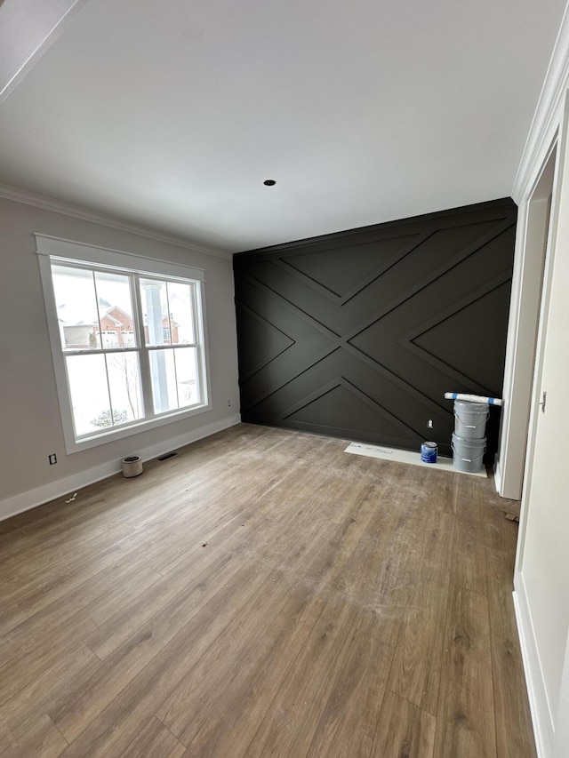 empty room featuring crown molding and light hardwood / wood-style floors