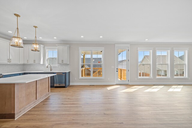 kitchen featuring white cabinetry, backsplash, light hardwood / wood-style floors, and a kitchen island