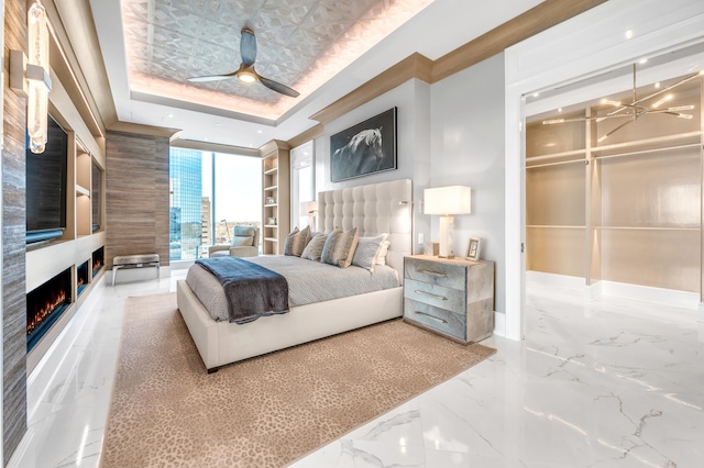 bedroom with tile floors, a closet, a raised ceiling, and ceiling fan with notable chandelier