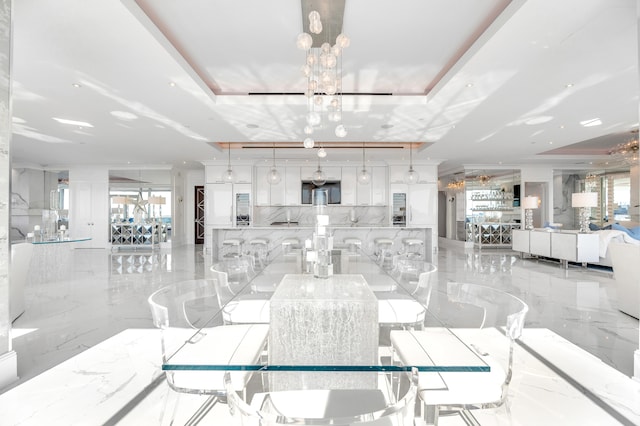 tiled dining space featuring an inviting chandelier and a raised ceiling