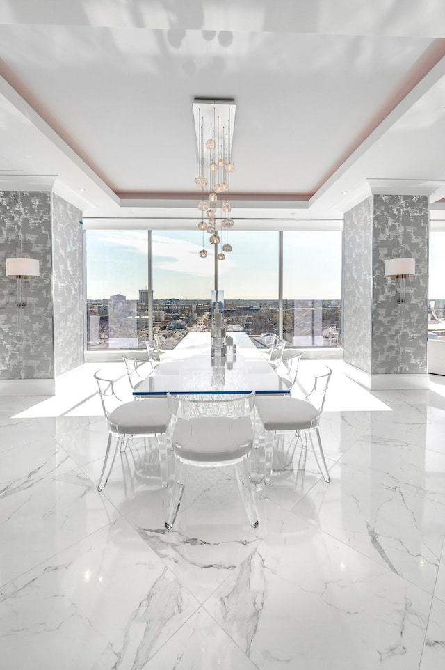 dining space with a tray ceiling, light tile floors, and expansive windows