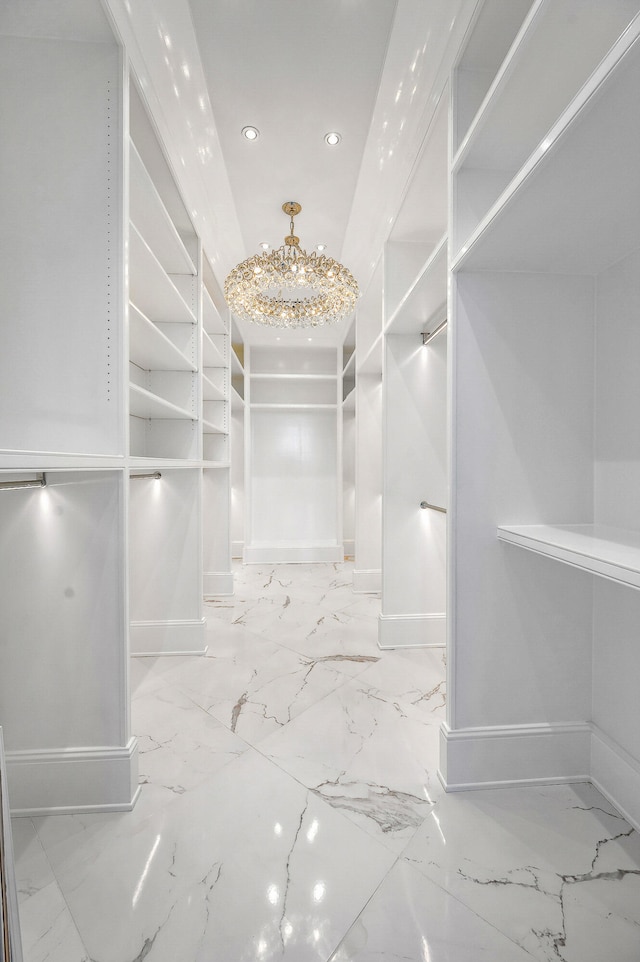 spacious closet with a notable chandelier and light tile floors