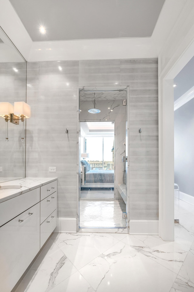 bathroom with tile flooring, tile walls, ornamental molding, and vanity