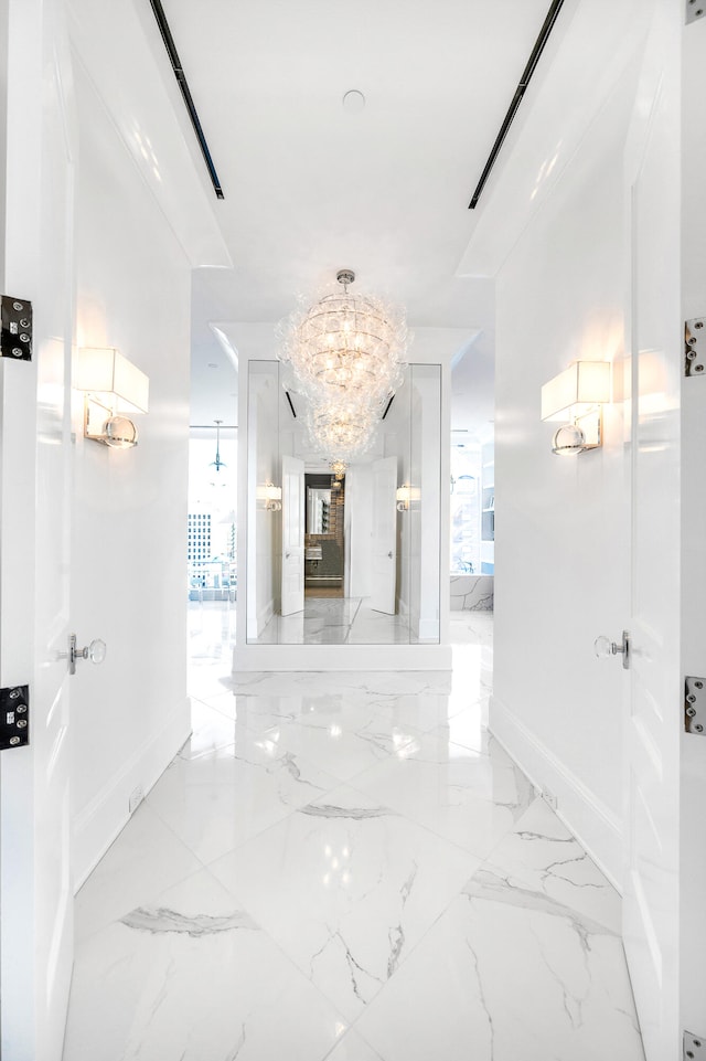 hallway featuring a notable chandelier and light tile flooring