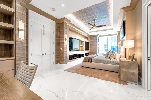 bedroom with a tray ceiling, tile flooring, and a closet