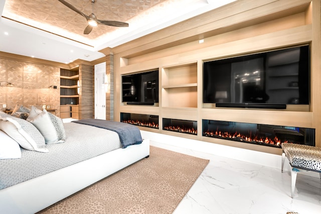 bedroom with a tray ceiling, tile flooring, and ceiling fan