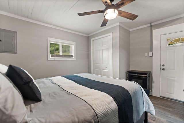 bedroom featuring a closet, hardwood / wood-style flooring, crown molding, electric panel, and ceiling fan