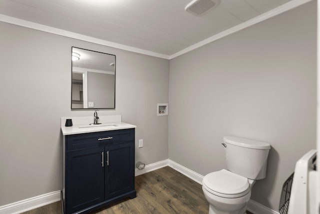 bathroom featuring vanity, toilet, hardwood / wood-style flooring, and crown molding