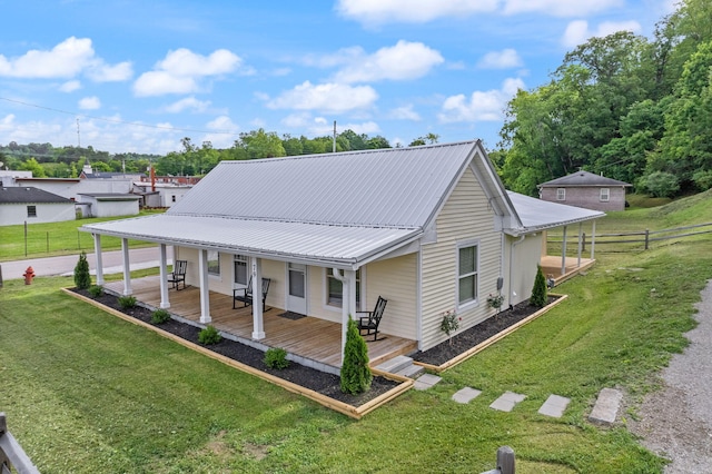 rear view of property with a porch and a lawn