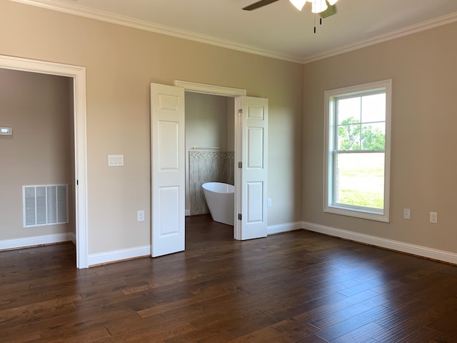 unfurnished bedroom with crown molding, dark wood-type flooring, ensuite bath, and ceiling fan